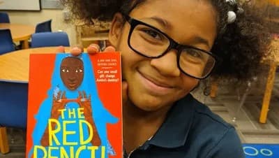 Student engaged in reading The Red Pencil, demonstrating the impact of community literacy programs